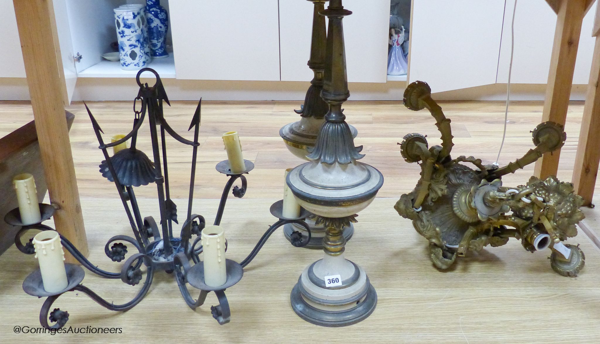 A cast brass electrolier, an ironwork exampleband a pair of table lamps